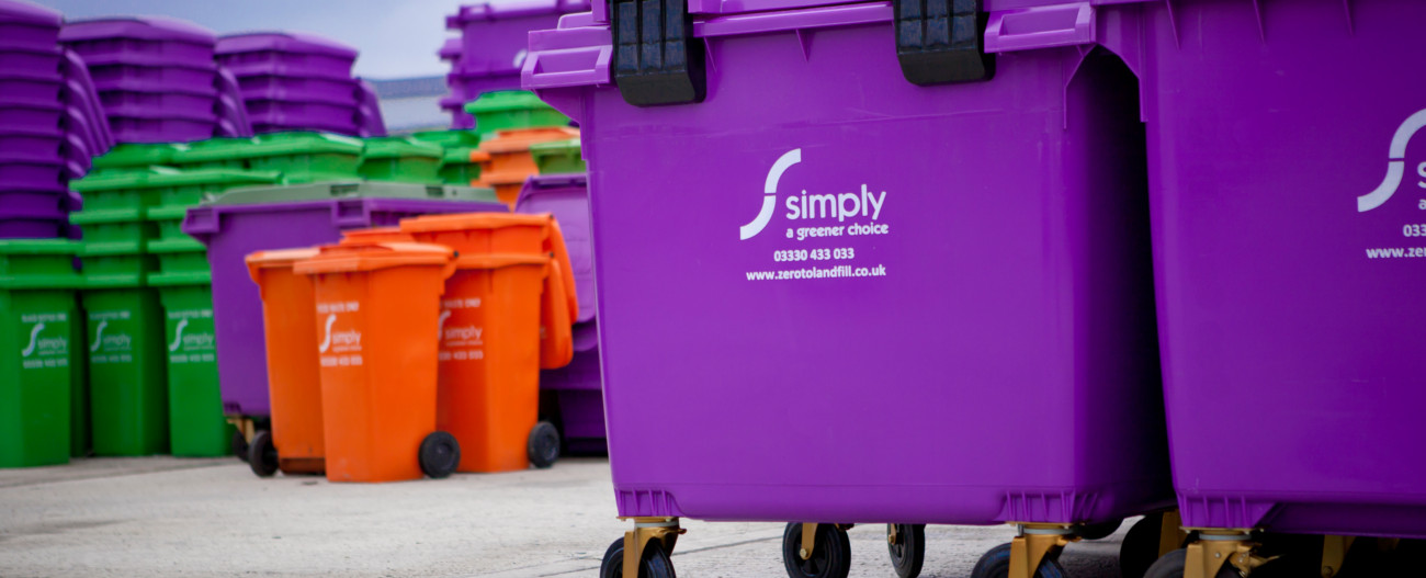 Simply Waste Solutions 1100 litre purple wheelie bins with 240 litre colour coded bins blurred in background
