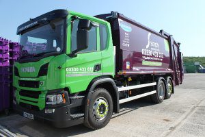 Simply Waste Solutions 2018 plate trade waste truck in Stanwell depot next to 1100 litre purple bins