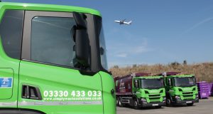 Simply Waste Solutions truck in Stanwell depot with Heathrow Airport plane flying over