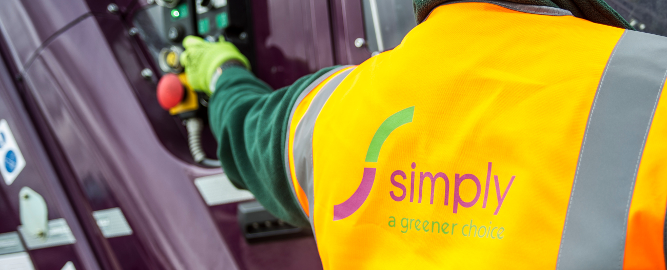 Simply Waste Solutions driver in high visibility jacket pressing bin lift button on truck 